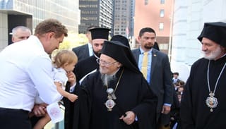 Pat. Bartholomew stops to greet a small child before entering the St. Nicholas National Shrine. Photo: Aaron Hickman/UOJ