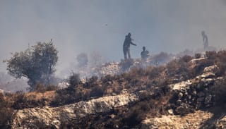 Masked Israeli settlers hurl rocks at Palestinians in the village of Sinjil on July 4. Photo: John Wessels/AFP via Getty