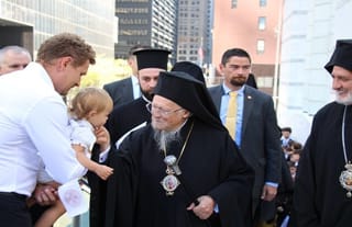 Pat. Bartholomew stops to greet a small child before entering the St. Nicholas National Shrine. Photo: Aaron Hickman/UOJ