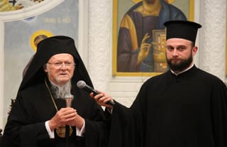Patriarch Bartholomew speaks to members of YAL as Patriarchal Deacon Barnabas Grigoriadis holds the microphone.