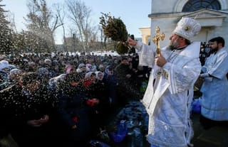 Metropolitan of Chisinau and All Moldova Vladimir splashes water on believers during Theophany celebrations in Chisinau, Moldova. January 19, 2019. Photo: REUTERS/Gleb Garanich