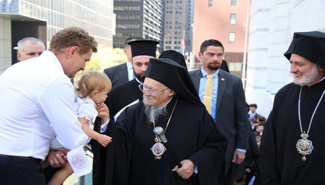 Pat. Bartholomew stops to greet a small child before entering the St. Nicholas National Shrine. Photo: Aaron Hickman/UOJ