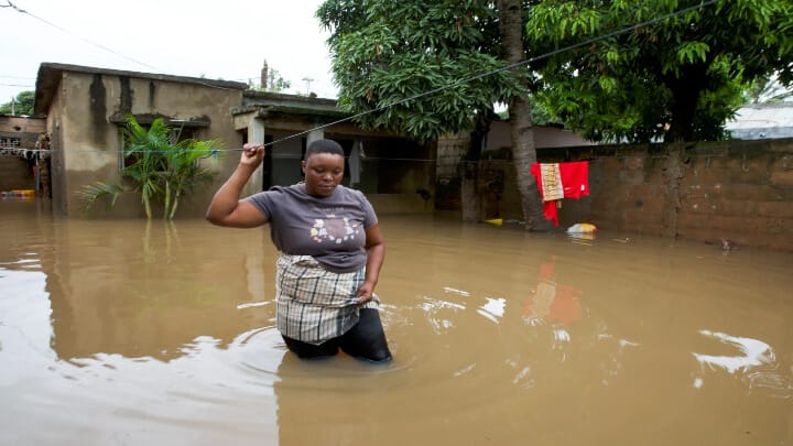 Telma Antonio, 36, stands in floodwater outside her inundated property after weeks of heavy rainfall in Maputo, Mozambique. Photo: Amilton Neves/Reuters