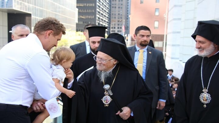 Pat. Bartholomew stops to greet a small child before entering the St. Nicholas National Shrine. Photo: Aaron Hickman/UOJ