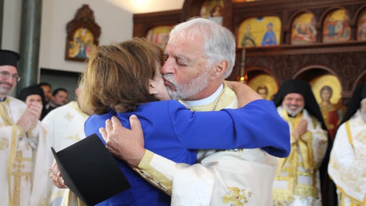 Fr. Alex Karloutsos kisses his wife, Xanthi, after being elevated to the rank of Megas Protopresbyteros. Photo: Aaron Hickman/UOJ