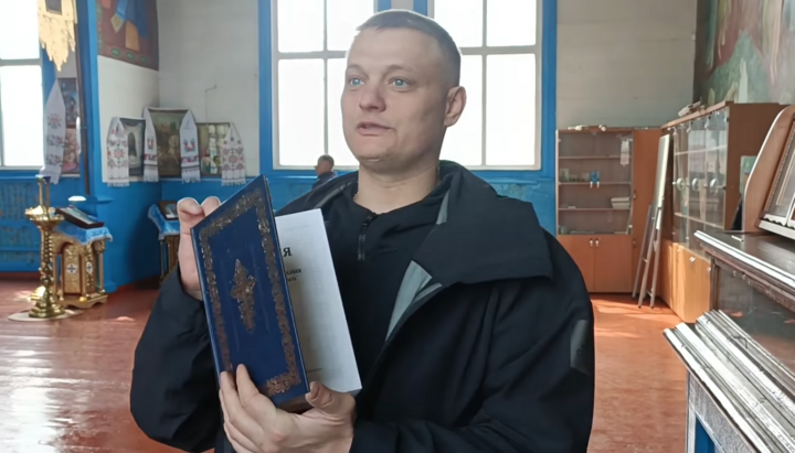 An OCU activist in Trebukhiv with a Bible, which he promised to "utilize". Photo: a video screenshot from Bondarenko's Facebook page