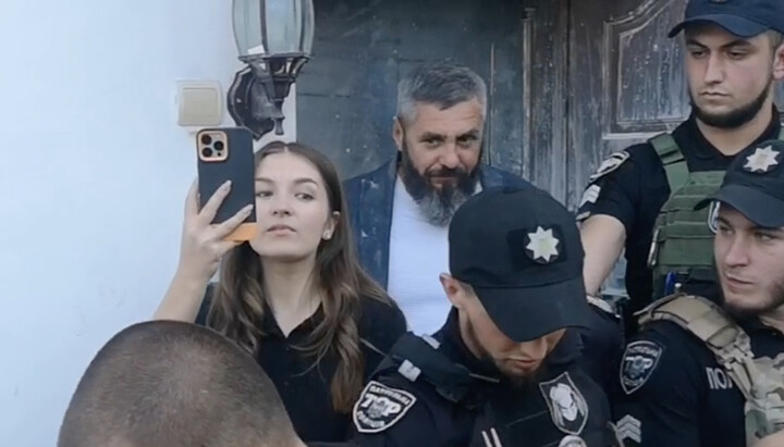 A woman leaves the altar of the Bila Tserkva Cathedral of the Ukrainian Orthodox Church. Behind her is Mykola Hopainych. Photo: screenshot t.me/pravoslavie