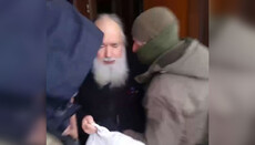 In Lavra, a police officer pushes a monk who was being delivered food