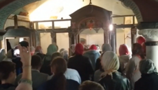 Believers hold a prayer standing at Tithe Church