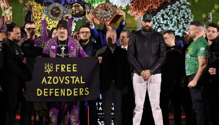 Oleksandr Usyk with a poster reading 