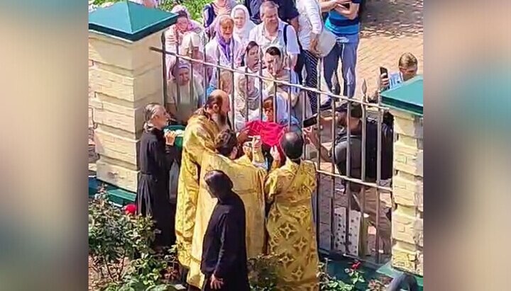 Communion through a lattice in the Lavra. Photo: UOJ